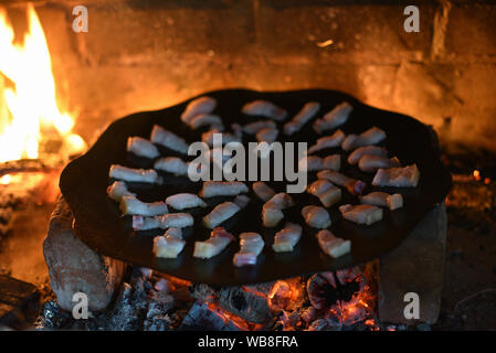 Salo ist in einer Pfanne in einem Ofen auf ein Feuer gebraten. Die Röstung Schmalz im Grill. Barbecue im Sommer im Freien. Schweinefett auf dem Scheiterhaufen. Kochen Street Food. r Stockfoto