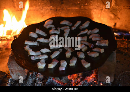 Salo ist in einer Pfanne in einem Ofen auf ein Feuer gebraten. Die Röstung Schmalz im Grill. Barbecue im Sommer im Freien. Schweinefett auf dem Scheiterhaufen. Kochen Street Food. r Stockfoto