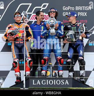 Suzuki's Alex Rins feiert den Sieg auf dem Podium mit Marc Marquez und Maverick Vinales während der GoPro MotoGP Grand Prix von Großbritannien in Silverstone, Towcester. Stockfoto