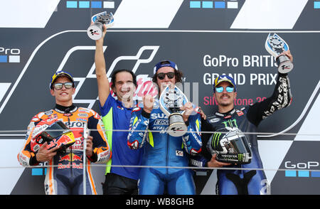 Suzuki's Alex Rins feiert den Sieg auf dem Podium mit Marc Marquez und Maverick Vinales während der GoPro MotoGP Grand Prix von Großbritannien in Silverstone, Towcester. Stockfoto