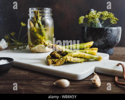 Eingelegter Spargel auf einem weißen Marmor fach Saisonale canning Gemüse Rezept. Stockfoto