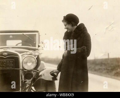 Gelbliches Foto von 1933 einer jungen Frau mit einem Ford Model A Sport Coupé um 1928-1932. Stockfoto