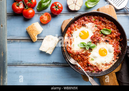 Shakshuka, gebratene Eier in Tomatensoße in eisernen Pfanne. Typische Israel essen. Ansicht von oben. Stockfoto