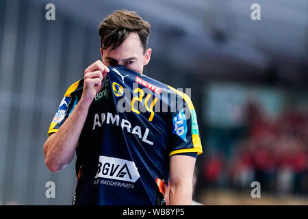 Ludwigshafen, Deutschland. 25 Aug, 2019. Handball: Bundesliga, Sterben Eulen Ludwigshafen - Rhein-Neckar-Löwen, 1.Spieltag, in der Friedrich-Ebert-Halle. Patrick Groetzki von der Rhein-Neckar-Löwen zieht die Jersey in seinem Gesicht. Foto: Uwe Anspach/dpa/Alamy leben Nachrichten Stockfoto