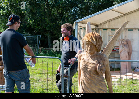 Tabley, Cheshire, UK. 25 Aug, 2019. Die 15 englischen Öffnen Kettensäge Wettbewerb im Cheshire County Showground, England - Simon O'Rourke Chats zu s Freund über den Zaun Credit: John Hopkins/Alamy leben Nachrichten Stockfoto