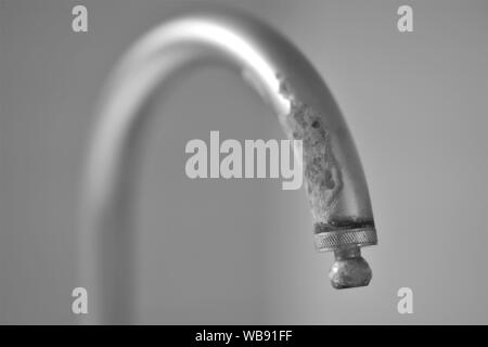 Alte Wasserhahn in Kalk, selektiver Fokus, Bw Stockfoto