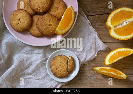 Knusprige Kekse mit kandierten Orangen in Scheiben geschnitten und orange auf einem Holz- Oberfläche. Im rustikalen Stil. Stockfoto