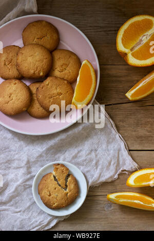 Knusprige Kekse mit kandierten Orangen in Scheiben geschnitten und orange auf einem Holz- Oberfläche. Im rustikalen Stil. Stockfoto