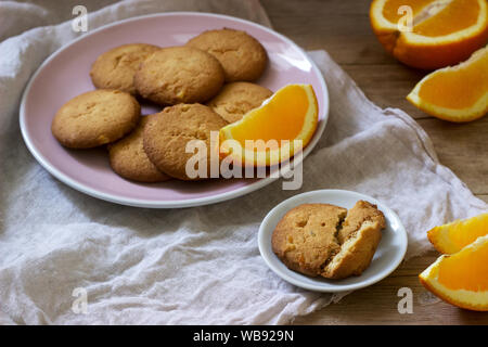 Knusprige Kekse mit kandierten Orangen in Scheiben geschnitten und orange auf einem Holz- Oberfläche. Im rustikalen Stil. Stockfoto