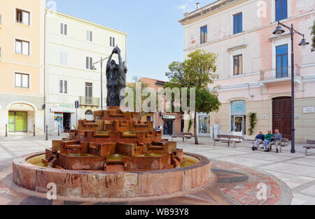 Olbia, Italien, 11. September 2017: älterer Mann sitzt am Brunnen am Platz am Corso Umberto I Straße in der Altstadt von Olbia auf der Insel Sardinien in Italien. Ältere Menschen und Stadt auf Italienisch Sardegna. Stockfoto