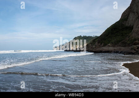 Weitwinkel Landschaft mit Strand, die Wellen des Pazifischen Ozeans und Klippen in winzigen Fischerdorf Canoa, Provinz Manabi, Ecuador nördlich von Bahia de Caraquez. Stockfoto