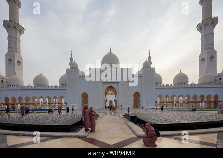 Touristen fotografieren vor dem Haupteingang, Sheikh Zayed Moschee, Abu Dhabi, Vereinigte Arabische Emirate Stockfoto