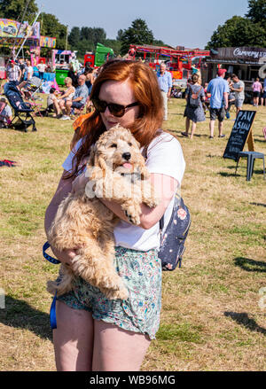 Tierhalter umarmen und trösten Hund bei sehr heißem Wetter, Harrogate Essen und Trinken Festival, Ripley, Harrogate, UK, 25. August 2019 Stockfoto