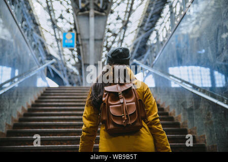 Frau klettern durch Treppen mit Rucksack Stockfoto