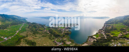 Antenne: Toba-See und die Insel Samosir Blick von oben Sumatra Indonesien. Riesige vulkanische Caldera von Wasser bedeckt, traditionelle Batak Dörfer, grüne Reis Stockfoto