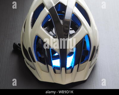 Weiß Fahrradhelm, blaue Beleuchtung im Inneren. Das Konzept der Kühlung. Stockfoto