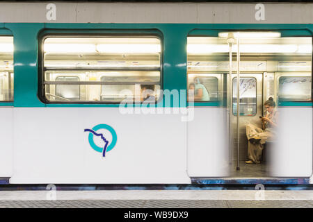 Pariser Metro-Szene - eine Frau an Ihr Telefon beim Warten auf den Zug zu verlassen. Frankreich, Europa. Stockfoto