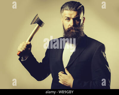 Hübscher junger Mann mit langem Bart und Schnurrbart in Schwarz Jacke Holding scharfe Axt in Studio auf grauem Hintergrund Stockfoto