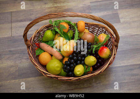 Korb mit frischen Früchten auf hölzernen Tisch. Äpfel, Pflaumen und ein Mountain Ash in einem Korb, Ansicht von oben. Tabelle - immer noch Leben. Frische saftige Zitrusfrüchte in einem Bas Stockfoto