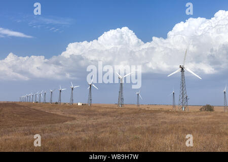 Strom bei Windkraftanlagen im Bereich gegen den Himmel Stockfoto