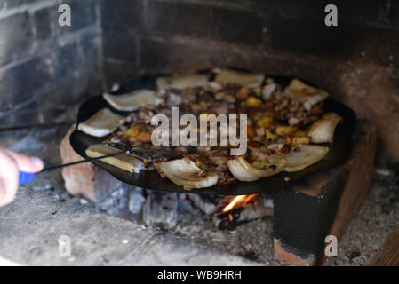 Salo ist in einer Pfanne in einem Ofen auf ein Feuer gebraten. Die Röstung Schmalz im Grill. Barbecue im Sommer im Freien. Schweinefett auf dem Scheiterhaufen. Kochen Street Food. r Stockfoto