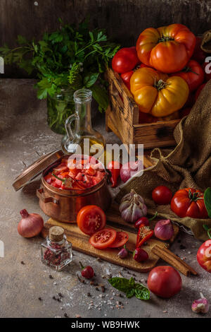 Tomaten auf Schneidebrett mit Messer, Ansicht von oben. Stockfoto