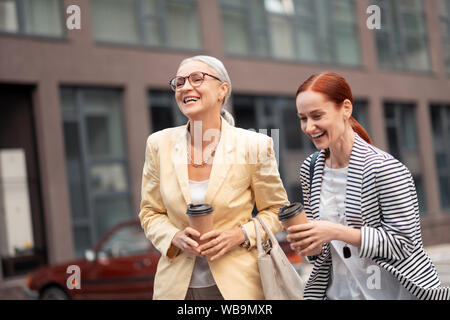Zwei erfolgreiche Unternehmerinnen ihre Papier Tassen Kaffee Durchführung Stockfoto