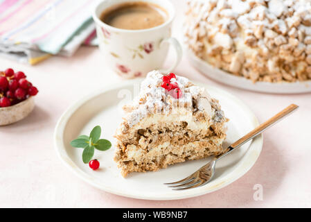 Haselnuss Daquoise Kuchen oder Kiew Kuchen mit Baiser Schichten und Vanilla buttercream serviert auf weiße Platte, rosa Hintergrund Stockfoto