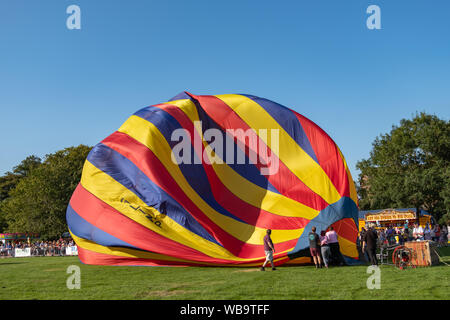 Strathaven, Schottland, Großbritannien. 25 Aug, 2019. Ein bunten Heißluftballon am Strathaven Ballon Festival, das in diesem Jahr feiert das 20-jähriges Jubiläum und ist in der preisgekrönten Strathaven Park gehalten aufgepumpt ist. Das Festival zieht die Piloten und Besucher aus ganz Europa, mit über 25.000 Zuschauern, die über das Wochenende. Credit: Skully/Alamy leben Nachrichten Stockfoto