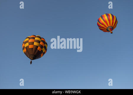 Strathaven, Schottland, Großbritannien. 25 Aug, 2019. Zwei Heißluftballons im Flug in Strathaven Ballon Festival, das in diesem Jahr feiert das 20-jähriges Jubiläum und ist in der preisgekrönten Strathaven Park gehalten. Das Festival zieht die Piloten und Besucher aus ganz Europa, mit über 25.000 Zuschauern, die über das Wochenende. Credit: Skully/Alamy leben Nachrichten Stockfoto