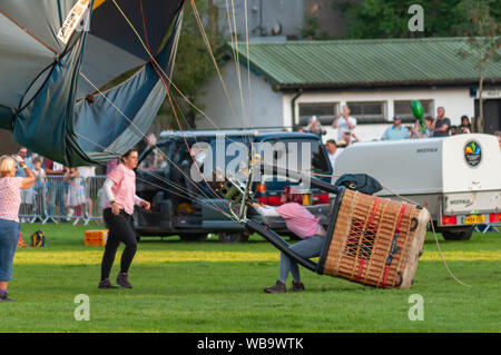 Strathaven, Schottland, Großbritannien. 25 Aug, 2019. Ein Pilot mit dem Brenner auf dem Boden in der Strathaven Ballon Festival, das in diesem Jahr feiert das 20-jähriges Jubiläum und ist in der preisgekrönten Strathaven Park gehalten. Das Festival zieht die Piloten und Besucher aus ganz Europa, mit über 25.000 Zuschauern, die über das Wochenende. Credit: Skully/Alamy leben Nachrichten Stockfoto