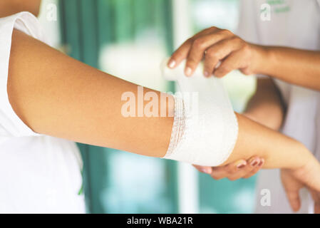 Winkelstück Wunde bandagieren Arm von der Krankenschwester/Erste Hilfe Handgelenkverletzung Gesundheitswesen und Medizin Konzept Stockfoto