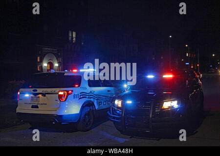 Ein paar Detroit Fahrzeuge der Polizei in der Straße in der Nacht geparkt mit Warnblinkleuchten blinken. Stockfoto