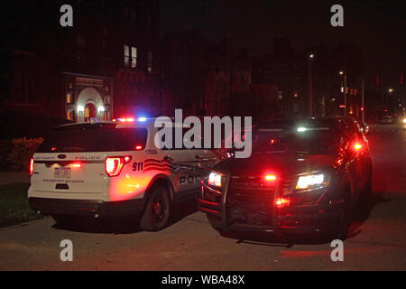 Ein paar Detroit Fahrzeuge der Polizei in der Straße in der Nacht geparkt mit Warnblinkleuchten blinken. Stockfoto