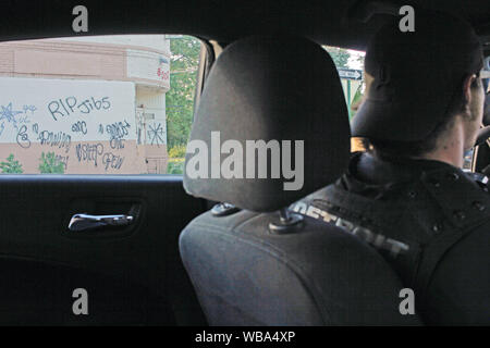 Detroit Polizei Special Ops Offizier Laufwerke hinter einem Gebäude covere din Schleifring Grafitti, Detroit, Michigan, USA Stockfoto