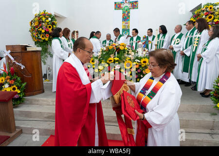 Weibliche lutherischen Klerus Mitglied ist als Bischof mit legendären Lutherischer Bischof Medardo Gomez von El Salvador Vorsitz bei der Auferstehung lutherischen Kirche in San Salvador geweiht. Gomez, ein Friedensnobelpreis nominierte, ist der Führer der Iglesia Luterana Salvadorena. Stockfoto