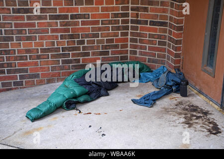 Eine obdachlose Personen Platz für die Nacht mit Fliegen befallene Kleidung und Nahrung, und Pflaster gebeizt mit Körperflüssigkeiten. Stockfoto