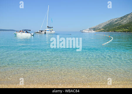 Segelboote vor der berühmten Kiesstrand Zlatni rat, türkisfarbene Meer Farbe, Insel Brac, Kroatien Stockfoto