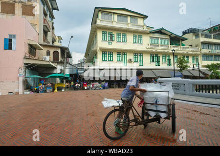 Eine mobile Eis Verkäufer übergibt eine große restaurierte Gebäude bei Saphan Han, einer Brücke über einen Klong (Kanal), in Chinatown/Pahurat, Bangkok, Thailand Stockfoto