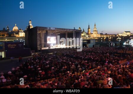 Dresden, Deutschland. 23 Aug, 2019. Besucher sitzen auf ihren Sitzen bei einem Konzert von Helge Schneider im Rahmen der Filmnächte am Elbufer vor der Kulisse der Altstadt. Credit: Sebastian Kahnert/dpa-Zentralbild/dpa/Alamy leben Nachrichten Stockfoto