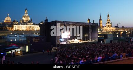 Dresden, Deutschland. 23 Aug, 2019. Besucher sitzen auf ihren Sitzen bei einem Konzert von Helge Schneider im Rahmen der Filmnächte am Elbufer vor der Kulisse der Altstadt. Credit: Sebastian Kahnert/dpa-Zentralbild/dpa/Alamy leben Nachrichten Stockfoto