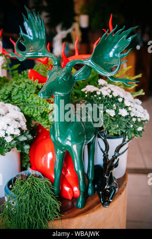 Februar 11, 2014 in Chiang Mai, Thailand-Ausführung Rot, Grün und Schwarz Keramik Reh moderne Skulpturen und weiße Blume Vasen, Übertopf auf Holz Tisch fo Stockfoto