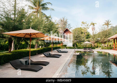 Mai 21, 2014 Krabi, Thailand - Coconut Resort Pool in einem tropischen Garten, Sonnenschirme und Sonnenliegen, Koh Lanta Tropical Resort Platz im Freien im Sommer Stockfoto