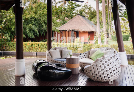 Mai 21, 2014 Krabi, Thailand - Moderne zeitgenössische tropischen asiatischen Stil Sofa, Kissen in der Hotellobby mit Gartenblick im Hintergrund Stockfoto