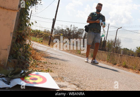 Inca, Spanien. 25 Aug, 2019. Nach einem Zusammenstoß zwischen einem Flugzeug und ein Hubschrauber, Wrackteile (l) liegen in der Nähe der Absturzstelle, während ein Mitglied der "Guardia Civil" Polizei geht. Am 25.08.2019, einem ultraleichten Flugzeug und ein Hubschrauber über der spanischen Ferieninsel Mallorca kollidierte - mit fatalen Folgen. Die Regierung der Balearen hat auf Twitter, dass mindestens fünf Menschen am frühen Nachmittag Unfall gestorben war. Quelle: dpa Picture alliance/Alamy leben Nachrichten Stockfoto