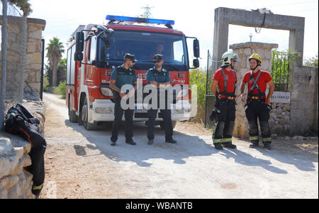 Inca, Spanien. 25 Aug, 2019. Mitglieder der "Guardia Civil" Polizeieinheit (l) und der Feuerwehr stehen in der Nähe der Absturzstelle nach einer Kollision zwischen einem Flugzeug und ein Hubschrauber. Am 25.08.2019, einem ultraleichten Flugzeug und ein Hubschrauber über der spanischen Ferieninsel Mallorca kollidierte - mit fatalen Folgen. Die Regierung der Balearen hat auf Twitter, dass mindestens fünf Menschen am frühen Nachmittag Unfall gestorben war. Quelle: dpa Picture alliance/Alamy leben Nachrichten Stockfoto
