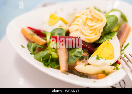 Kartoffelsalat mit roten Rüben, geräucherten Hering, Ei und Soja - bean Mayonnaise Stockfoto