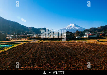 Schneebedeckten Berg Fuji und Lokalen der Stadt entlang der Strecke von Tokio nach Kawaguchiko durch Zug Fenster mit einigen Spiegel gesehen spiegeln auf der linken Seite Stockfoto