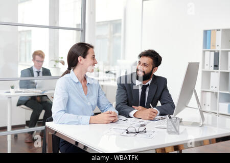 Kollegen am Schreibtisch sitzen zusammen Stockfoto