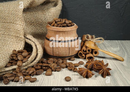 Kaffeebohnen überlaufen von einem kleinen Topf, würzige, Sternanis und Zimtstangen in einem rustikalen noch Leben auf einem Holztisch mit Platz kopieren Stockfoto